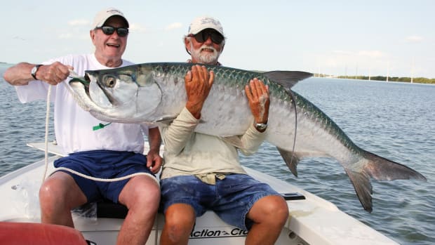 The 41st U.S. president caught and released his bucket list tarpon in the Keys with Capt. George Woods (right) and Andy Mill.