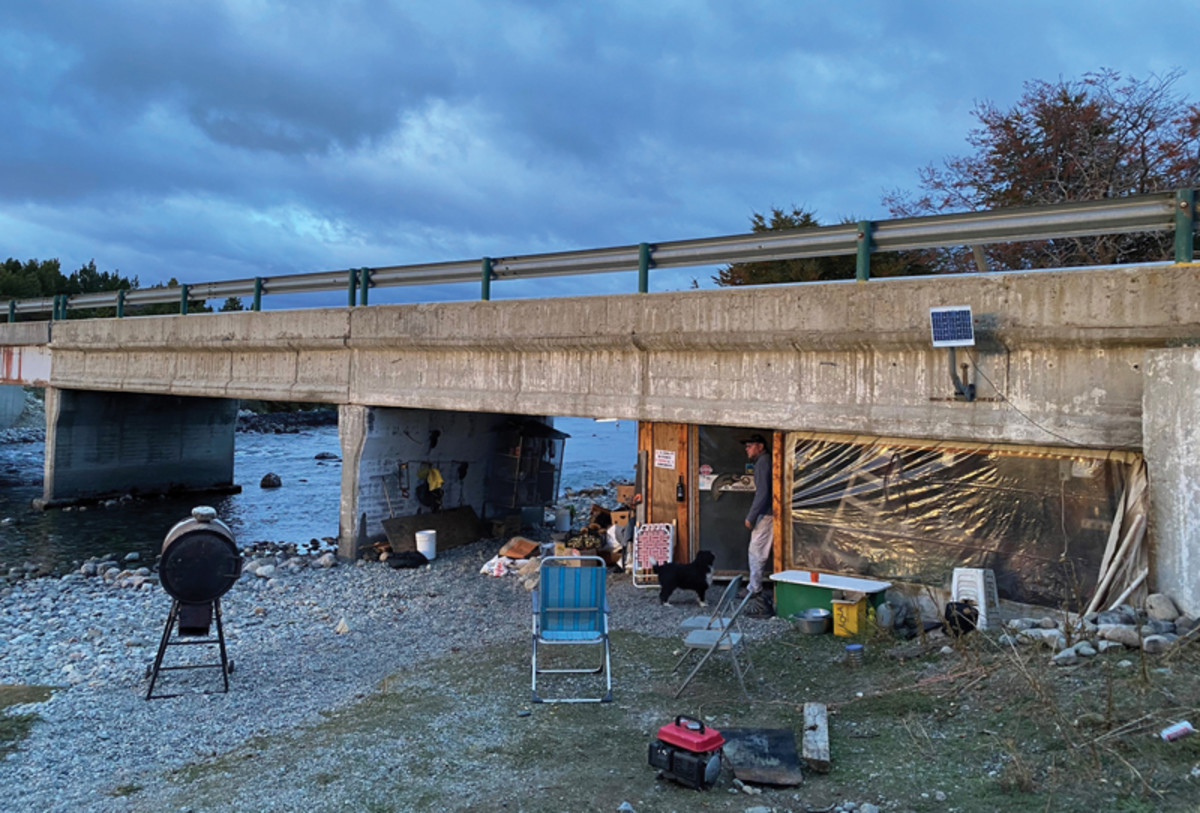 Each season, Paulino and his fellow trout devotees build the "boca camp" under a bridge that crosses the Rio Corcovado, with bunks, tables and a wood stove. 